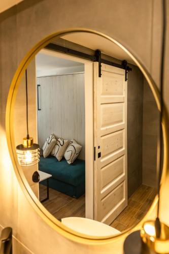 a mirror reflecting a bedroom with a blue couch at Studio Deluxe RoMa II in Imotski