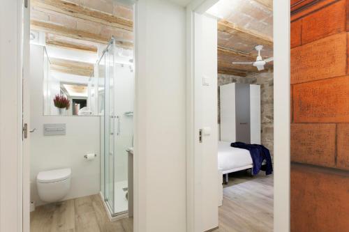 Un baño con inodoro y una cama en una habitación. en Barcelona Classic Palau Apartments, en Barcelona
