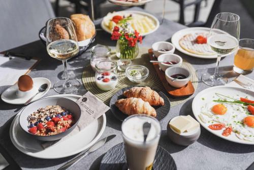 a table with plates of food and glasses of wine at Guesthouse Karnatsch in Parcines