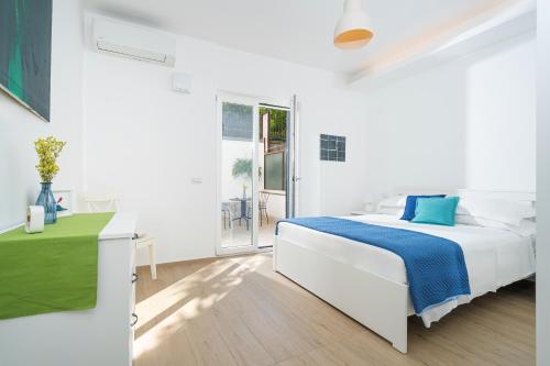 a white bedroom with a white bed and a window at Casa Stella in Vico Equense