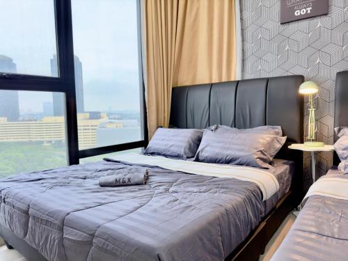 a bedroom with a large bed and a large window at MidValley Southkey Mosaic 6-9pax Netflix-SmartTV70inch in Johor Bahru