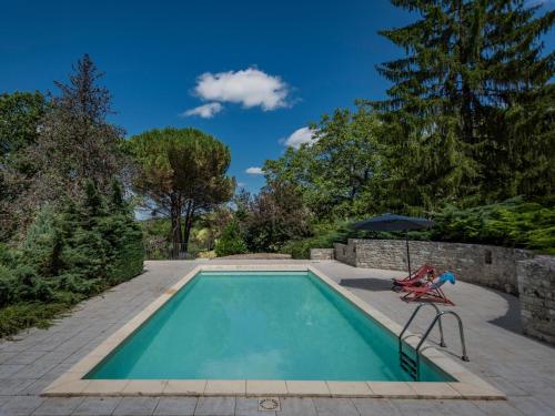 - une piscine avec une chaise et un parasol dans l'établissement Vigne Grande, à Puy-lʼÉvêque