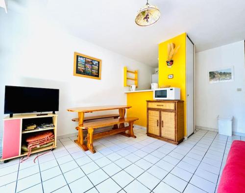 un salon avec une table et une télévision dans l'établissement Le Grand Large, à Collioure