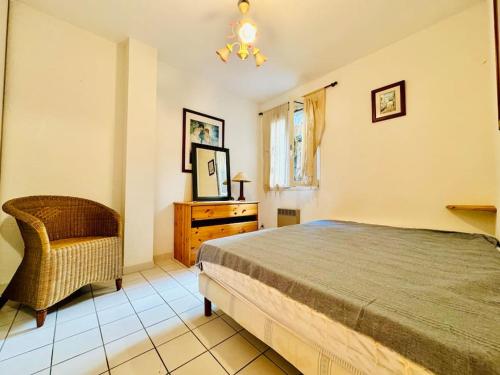 une chambre avec un lit, une chaise et une fenêtre dans l'établissement Le Grand Large, à Collioure