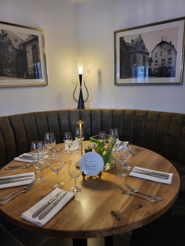 a wooden table with wine glasses and napkins at Hotel Restaurant Alte Stadtmauer in Beilstein