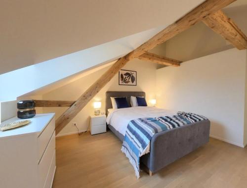 a bedroom with a large bed in a attic at Bright and Airy 1-Bedroom Flats in Neuchâtel City Center! RDM2 in Neuchâtel
