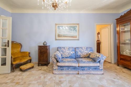a living room with a blue couch and a chair at Casa Torre San Romano in Lucca