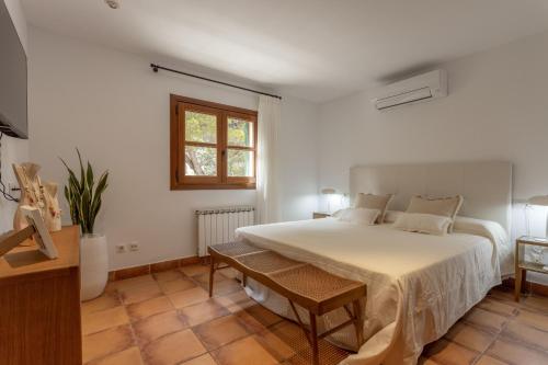 een slaapkamer met een groot wit bed en een raam bij Villa Martina in Can Picafort