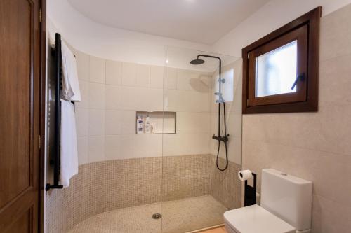 een badkamer met douche, toilet en raam bij Villa Martina in Can Picafort