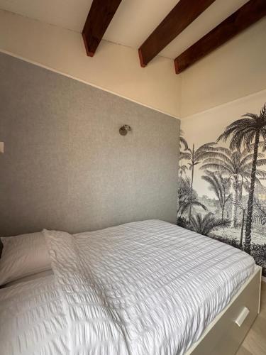 - une chambre avec un lit orné d'une fresque murale de palmiers dans l'établissement Évasion Sétoise - Appartement avec balcon vue marina, climatisé, parking - Situé à 200m de la plage, à Sète
