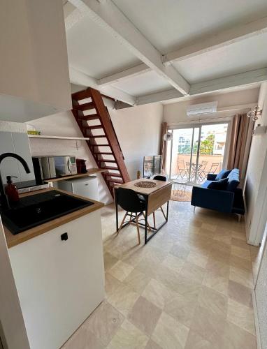 Il comprend une cuisine et un salon avec une table. dans l'établissement Évasion Sétoise - Appartement avec balcon vue marina, climatisé, parking - Situé à 200m de la plage, à Sète