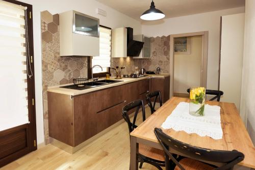 a kitchen and dining room with a wooden table and chairs at Casa di Nonna Rosa e Nonno Ciccito in Masullas