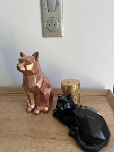 deux sculptures d'un chat assis sur une table dans l'établissement VILLA RIZEE à 14min de Paris & proche DisneyLand Resort, à Chelles