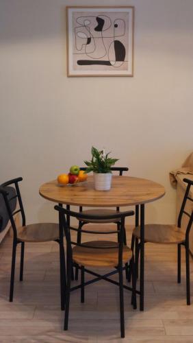 a wooden table with chairs and a bowl of fruit on it at Miranda's Apartment Koukaki in Athens