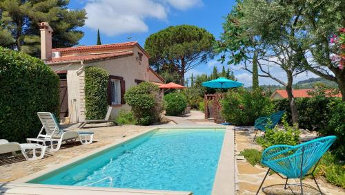 une piscine avec des chaises et une maison dans l'établissement la beaussetane, au Beausset