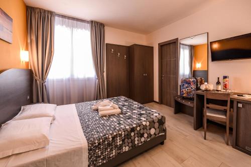 a bedroom with a bed and a desk with a mirror at Hotel Rainbow Resort in Marsala