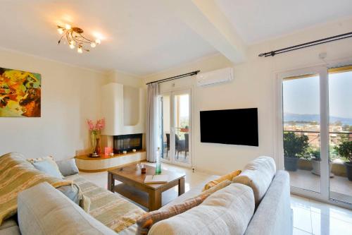 un salon avec un canapé et une télévision dans l'établissement Corfu SeaTy Apartment, à Corfou