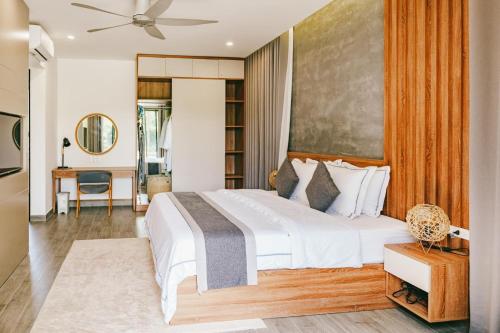 a bedroom with a large white bed and a desk at Villa Luxury 3 Phòng ngủ Private Pool - Coastar Hồ Tràm in Long Hai
