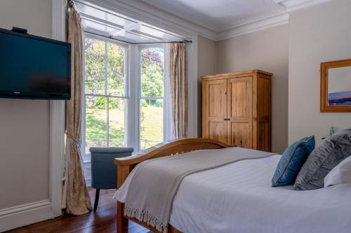 a bedroom with a bed and a large window at Broomfield House in Whitby