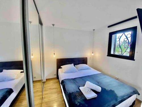 a bedroom with two beds and a window at MarinesAppartement, La terrasse Tropézienne in Saint-Tropez