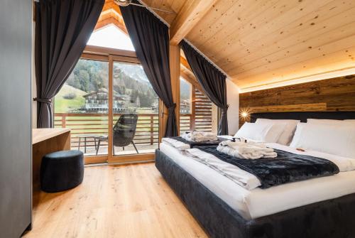 a bedroom with a large bed and a large window at Chalet Lumis in San Vigilio Di Marebbe