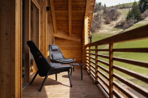 two chairs sitting on the porch of a cabin at Chalet Lumis in San Vigilio Di Marebbe
