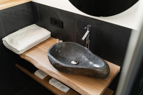 a black sink on a wooden counter in a bathroom at Chalet Lumis in San Vigilio Di Marebbe