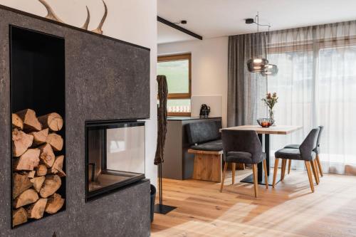 a living room with a fireplace and a table with chairs at Chalet Lumis in San Vigilio Di Marebbe