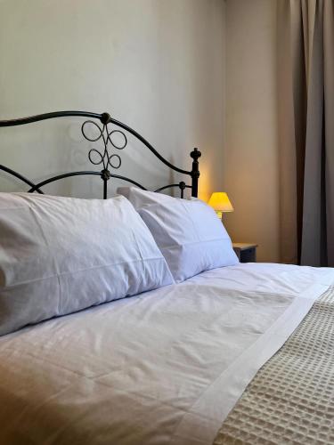 a bed with white pillows and a black head board at The Monna Lisa Resort in Arezzo