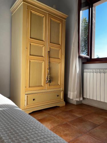 a large wooden cabinet in a bedroom with a window at The Monna Lisa Resort in Arezzo