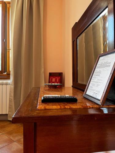 a remote control sitting on top of a wooden table at The Monna Lisa Resort in Arezzo