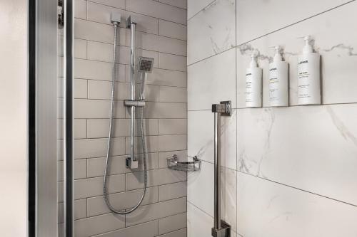 a bathroom with a shower with two bottles on the wall at The American Hotel Atlanta Downtown, Tapestry Collection by Hilton in Atlanta