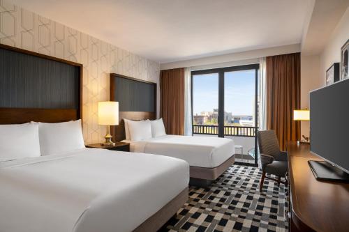a hotel room with two beds and a desk at The American Hotel Atlanta Downtown, Tapestry Collection by Hilton in Atlanta