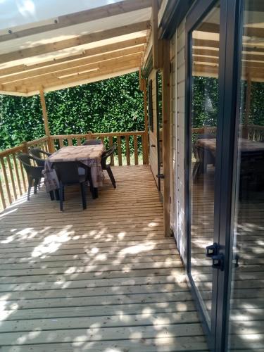 a wooden deck with a table and chairs on it at Camping de Marcilly sur Vienne in Marcilly-sur-Vienne