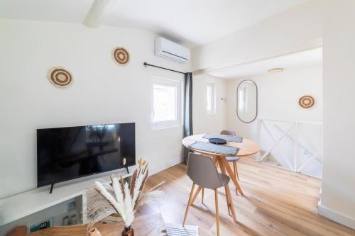 un salon avec une table et une télévision dans l'établissement Le Belvédère Nîmois proche centre ville Clim &Véranda MaisonCarréeConciergerie, à Nîmes