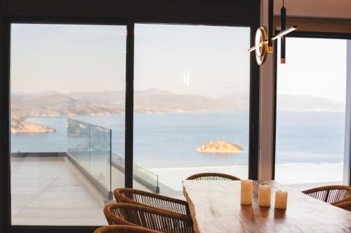 a table with chairs and a view of the ocean at Panoramic Villa in Tolo
