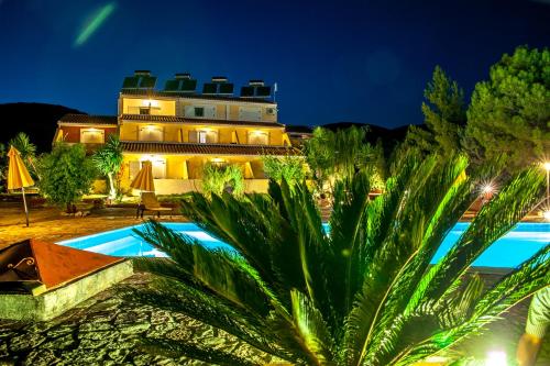 a resort with a swimming pool in front of a building at Pegasos Studios in Karavadhos