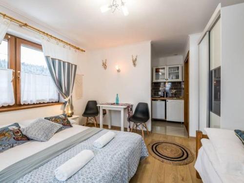 a bedroom with a bed and a table and chairs at Domek z Góralską Duszą Śleboda in Jurgów