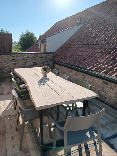 a wooden table and chairs on a roof at De Reiziger in Stavele