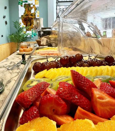 a tray of fruit on a buffet table at 19 Tile Ceramic Concept - by Unlock Hotels in Caldas da Rainha