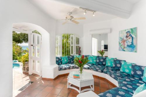 a living room with a blue couch and a table at Merlin Bay Beach Villas in Saint James