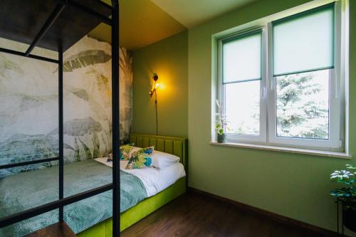 a bedroom with a bunk bed and two windows at Jungle Apartment chill&bed Zator in Zator