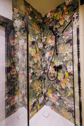 a shower in a room with a floral wallpaper at Jungle Apartment chill&bed Zator in Zator