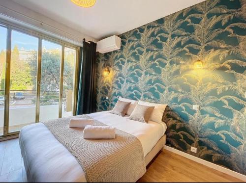 - une chambre avec un grand lit et du papier peint floral dans l'établissement Spacieux appartement à Nice 4 chambres, à Nice