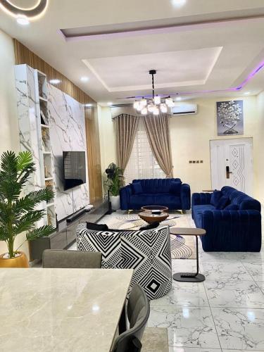 a living room with blue couches and a tv at Urban apartment in Lagos