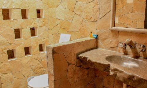 a stone bathroom with a sink and a toilet at Hotel Na Bolom in San Crist&oacute;bal de Las Casas