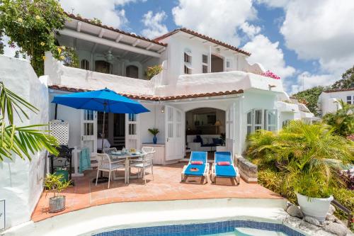 a villa with a swimming pool and a house at Merlin Bay Beach Villas in Saint James
