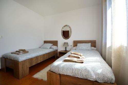 a bedroom with two beds and a mirror at Casa frente al mar en A Illa de Arousa in Isla de Arosa