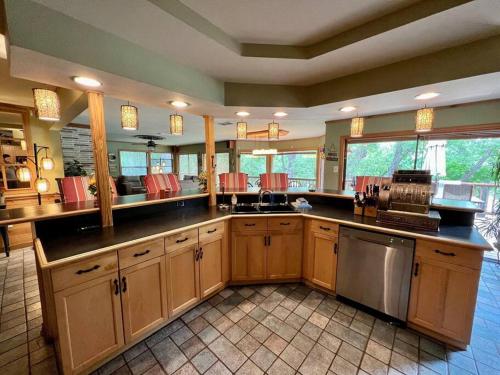 a large kitchen with wooden cabinets and a counter top at The River Haven - Sleeps 32 - on Guadalupe River in Seguin