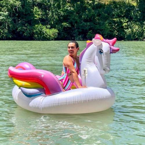 a woman is riding on a unicorn raft in the water at The River Haven - Sleeps 32 - on Guadalupe River in Seguin